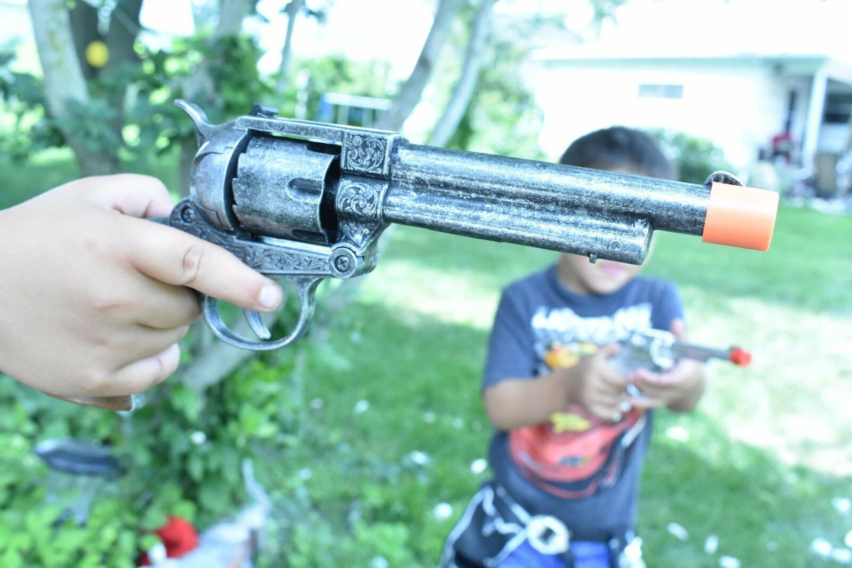 Child holding a toy revolver outdoors with a blurred background for Parris Toys 4603C