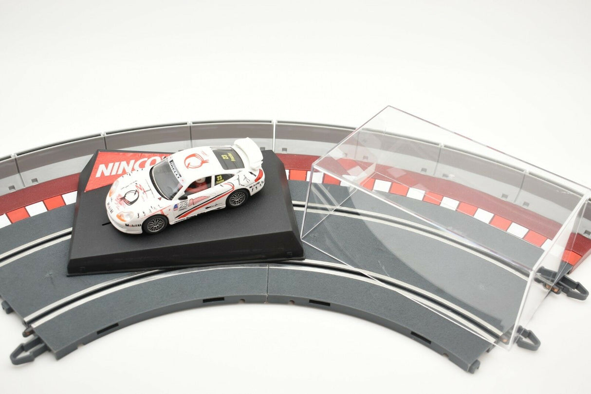 White Porsche race car on a track section with clear barriers for Ninco 50210