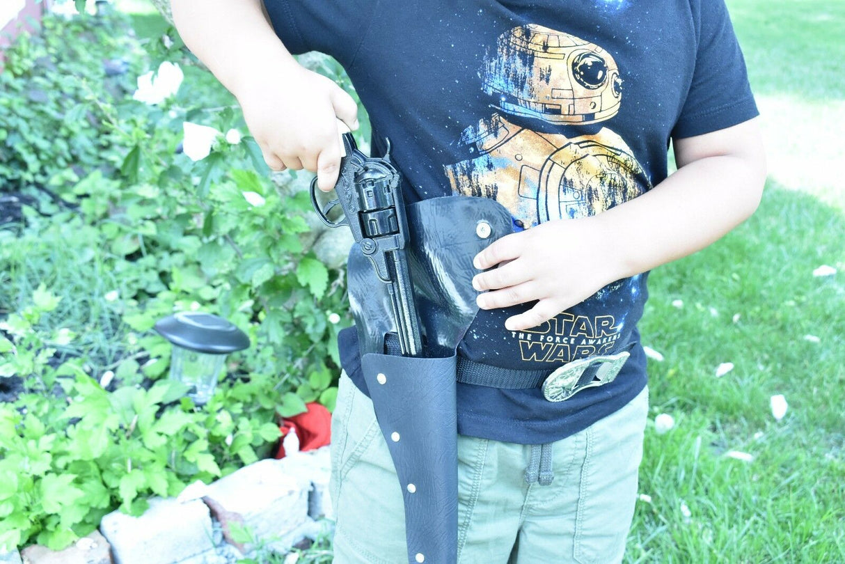 Child holding a black revolver and holster against a green outdoor background for Parris Toys 0652