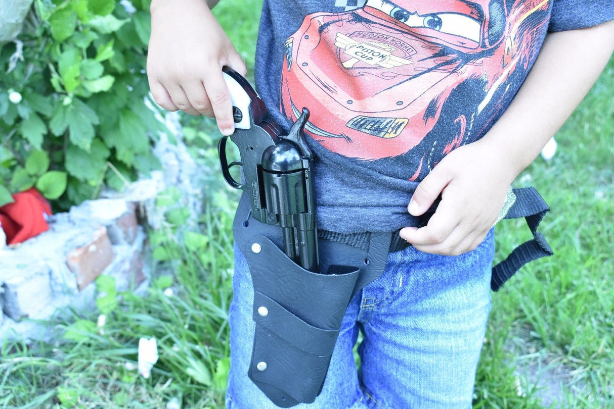Child holding toy gun holster with toy pistol against a green, outdoor background for Parris Toys 4708B