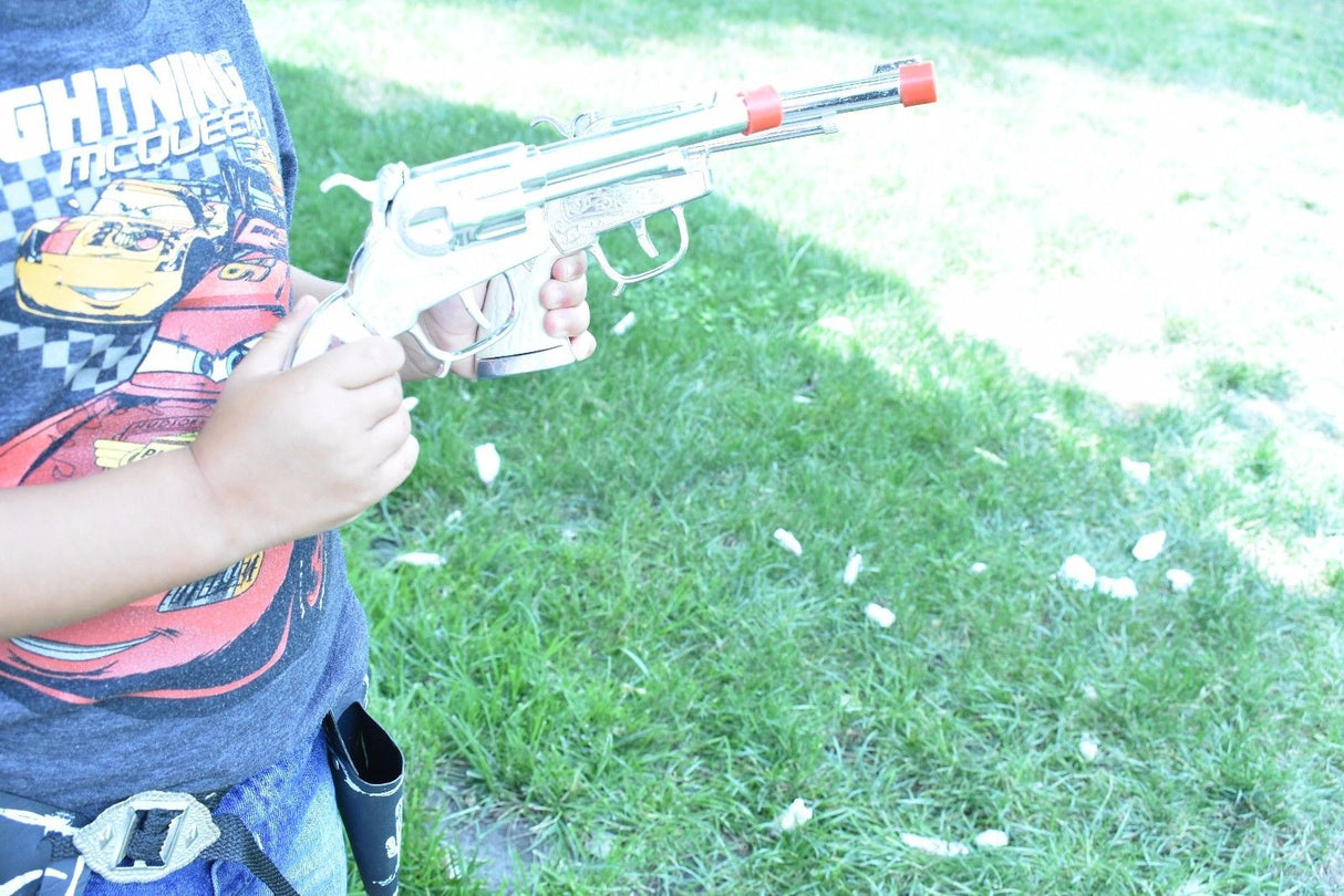 Child holding a toy western repeater pistol outdoors on green grass for Parris Toys 5506