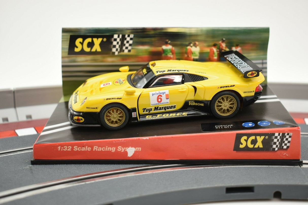 Yellow Porsche 911 GT1 race car on a track base for SCX Analog 60150, alternate track view