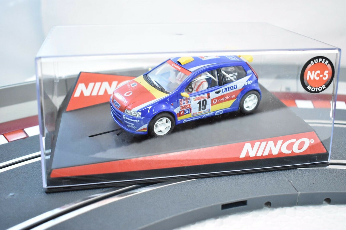 Blue and red slot car, Fiat Punto, on a display base for NINCO 50336