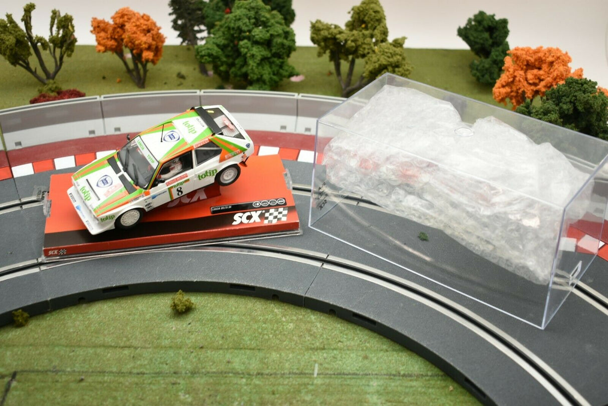 Race car on track with clear plastic case nearby for SCX A10153X3U0
