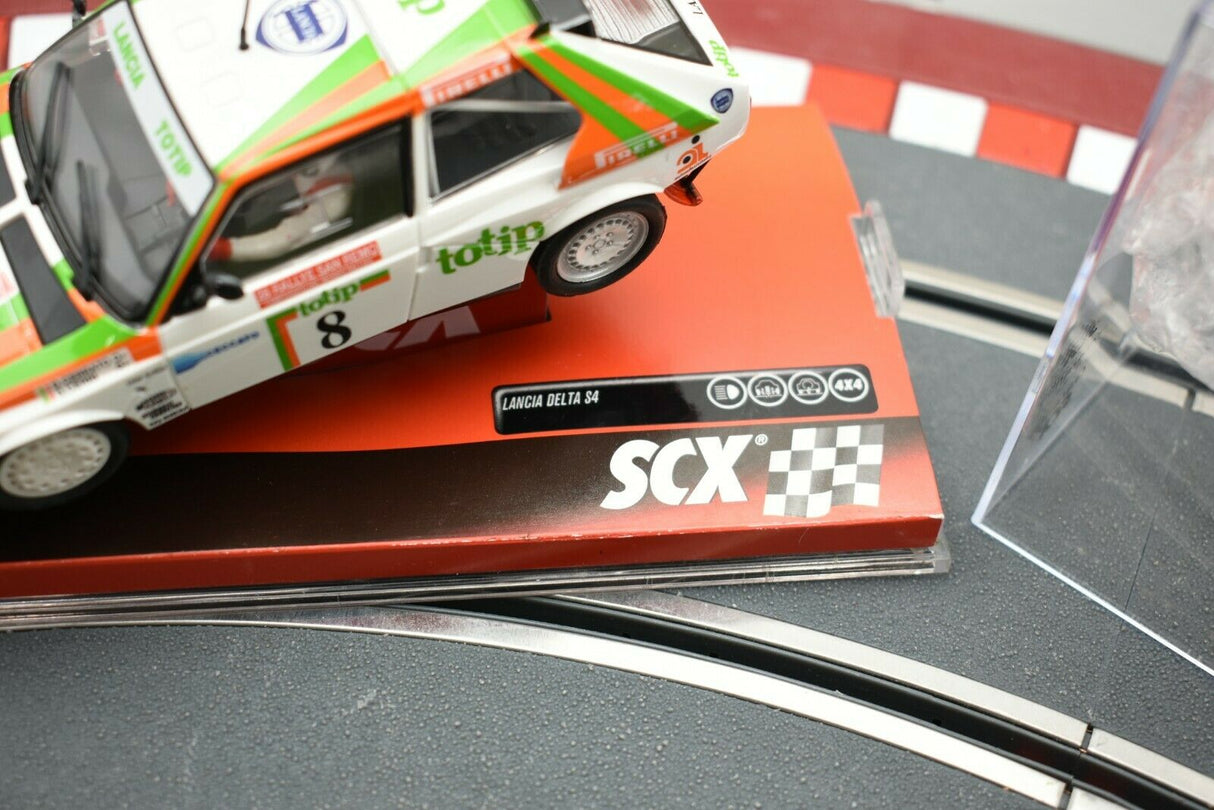 Miniature race car on a track section with "Lancia Delta S4" branding for SCX A10153X3U0