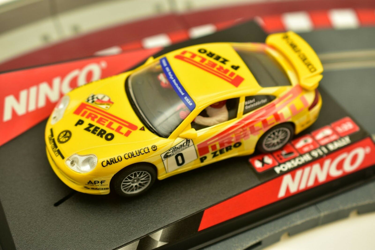 Yellow Porsche 911 race car with "Pirelli" and "Ninco" branding on a track for 50256