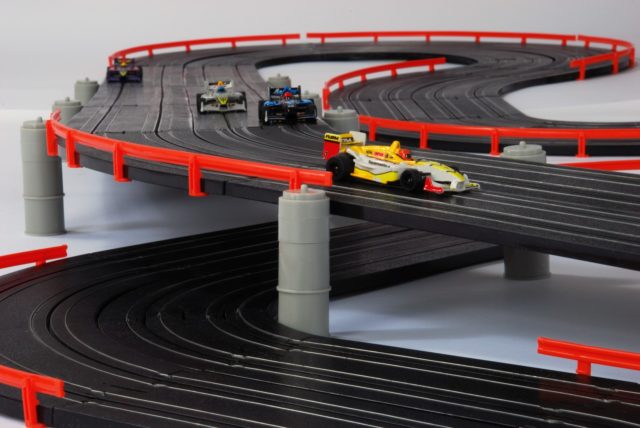 Race track with toy cars on a curved, multi-level black and red surface for AFX/ 21018