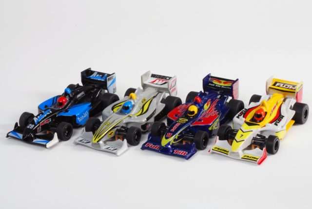 Assortment of four colorful, slot car race cars lined up for AFX/ 21018