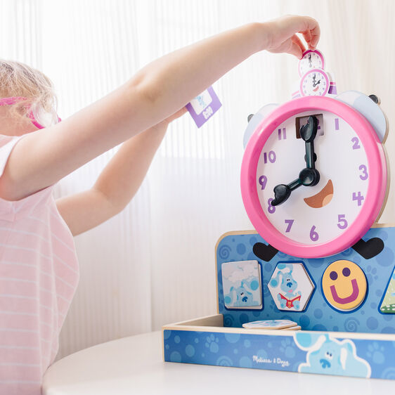 Child interacts with a Blue's Clues wooden magnetic clock toy for Melissa and Doug 33014