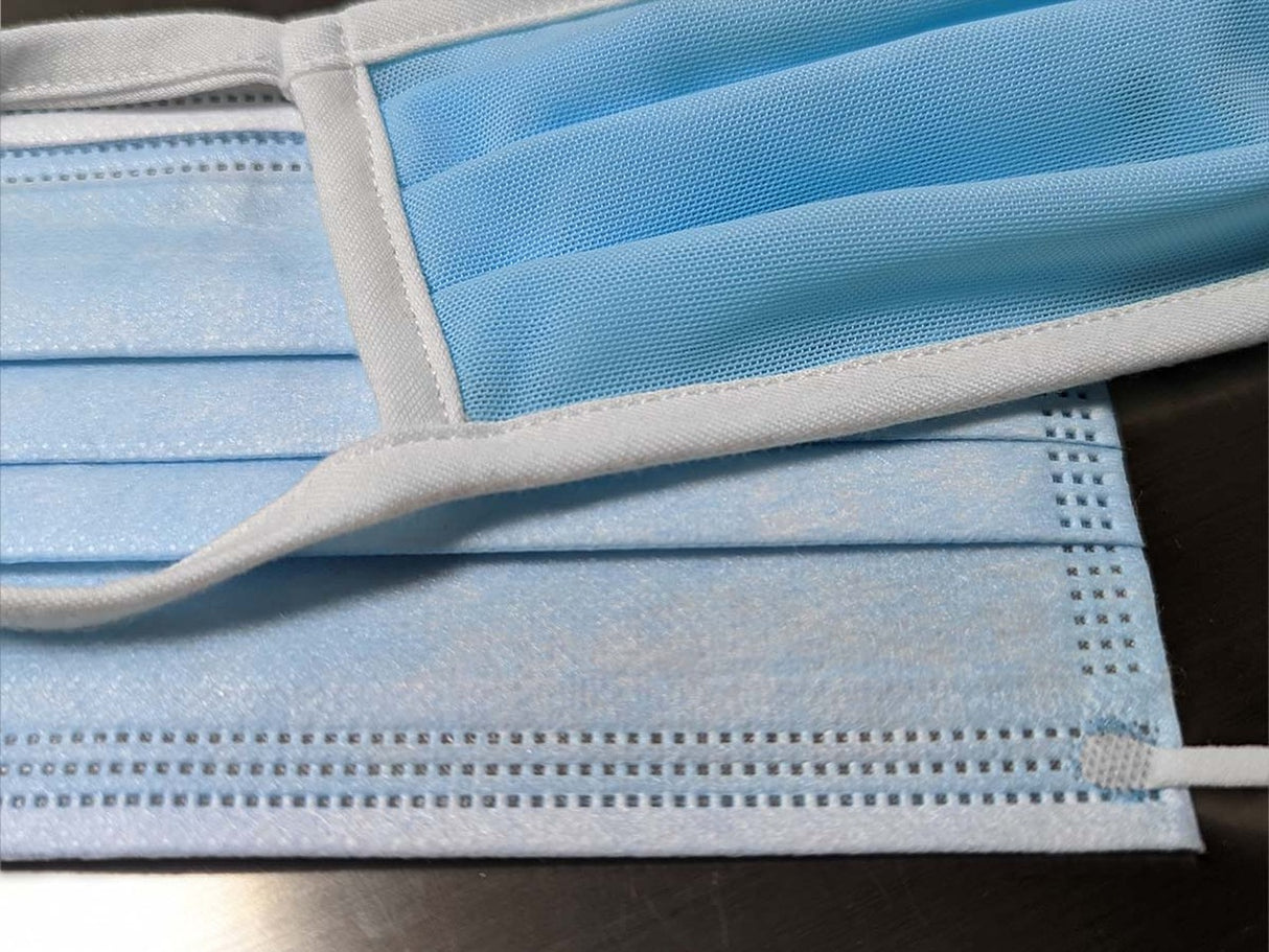 Folded light blue face masks with white ear loops for Fake Mask USA