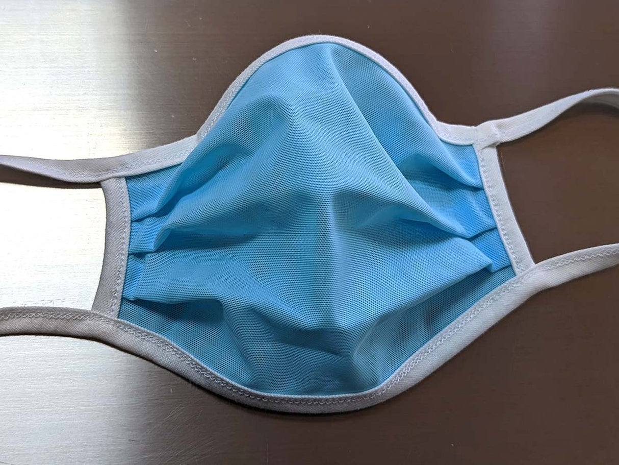 Light blue disposable face mask with ear loops on a surface for Fake Mask USA