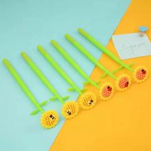 Green pens with sunflower, ladybug, and bee toppers arranged on blue and yellow surface for BCmini 22429