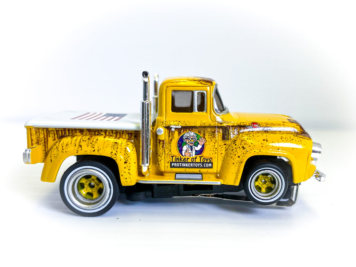 Yellow 1956 Ford F-100 pickup truck toy with delivery markings for Auto World