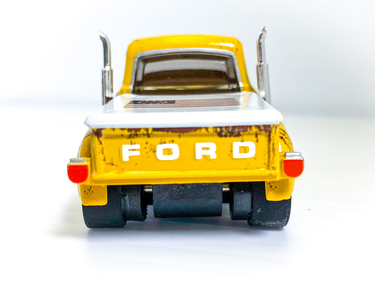 Yellow slot car of a 1956 Ford F-100 pickup truck viewed from the rear for Auto World