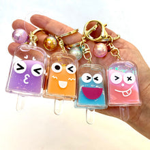 Set of four colorful, cute popsicle face key charms on a hand for BC Mini 12063