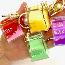 Assortment of colorful, scented milk key charms held in a hand for BC Mini 12058