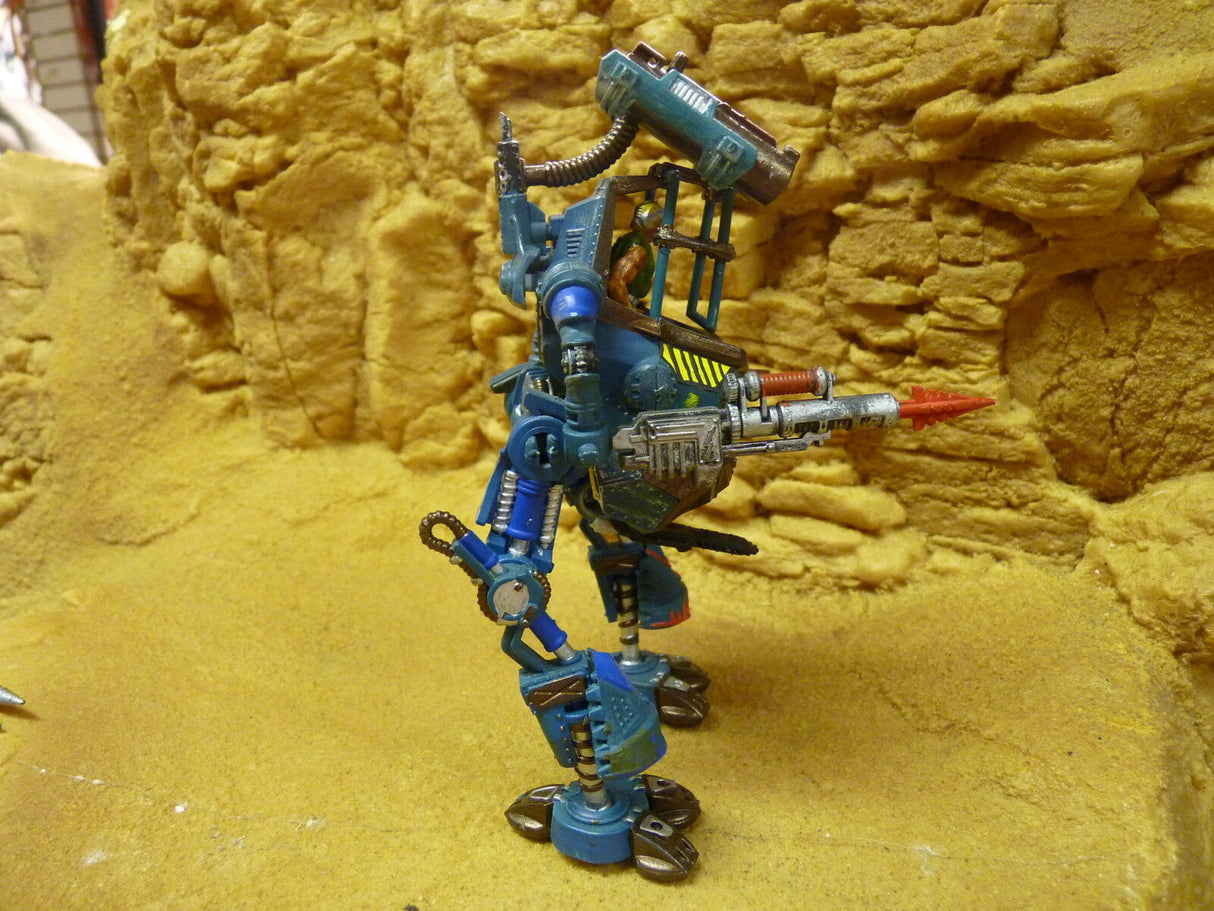 Blue robot action figure with weapon, standing on yellow textured surface for Robogear 6007