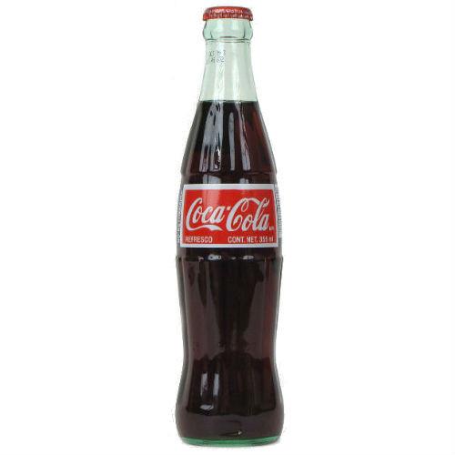 Dark soda beverage in a glass bottle with a red and white label for Coca-Cola 00463