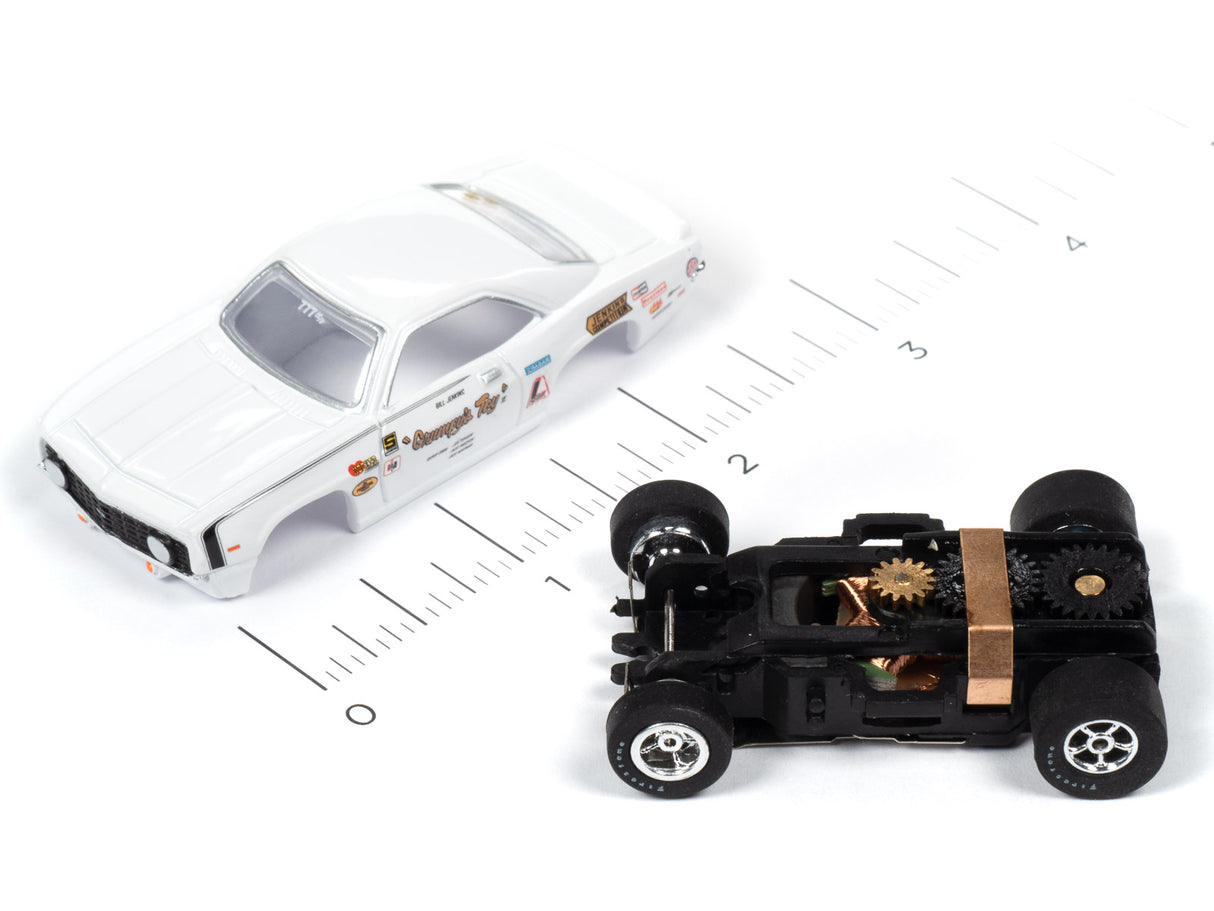 White 1969 Camaro slot car next to a black slot car on a ruler for Auto World 1969 Chevrolet Camaro