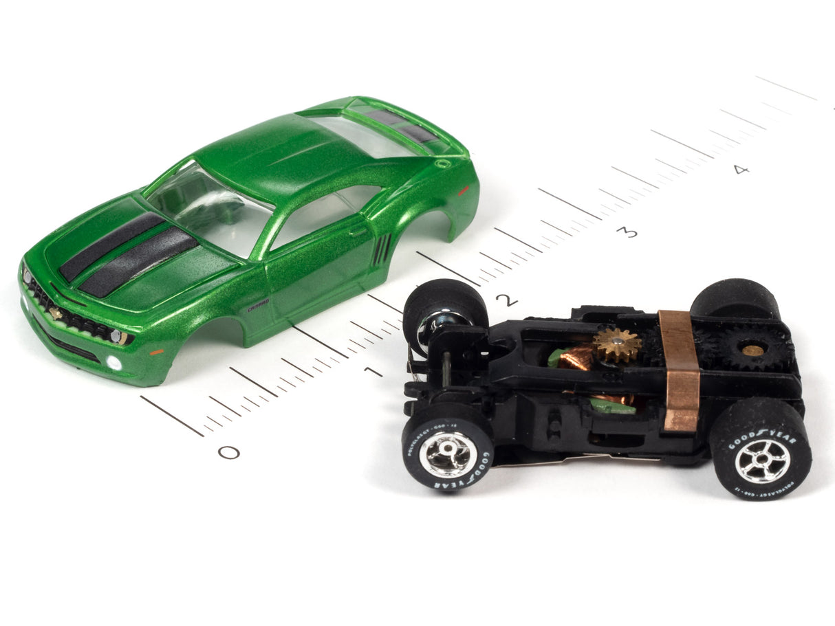 Green muscle car and black hot rod slot cars on a ruler for Auto World SC354