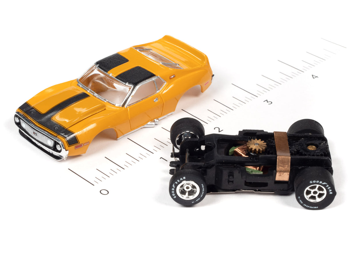 Yellow muscle car and black remote-controlled car on a ruler for Auto World SC354
