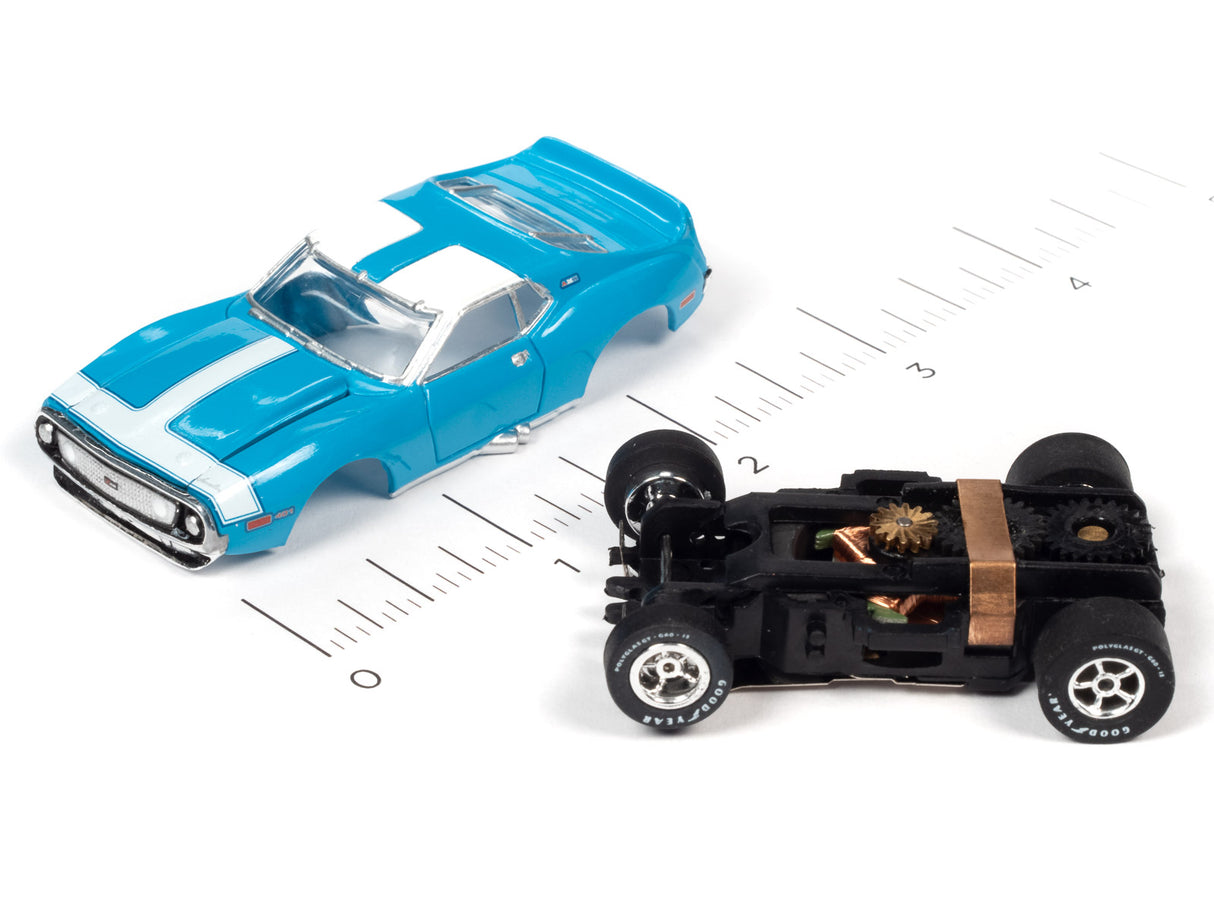 Blue slot car muscle car and black slot car on a ruler for Auto World SC354, front view