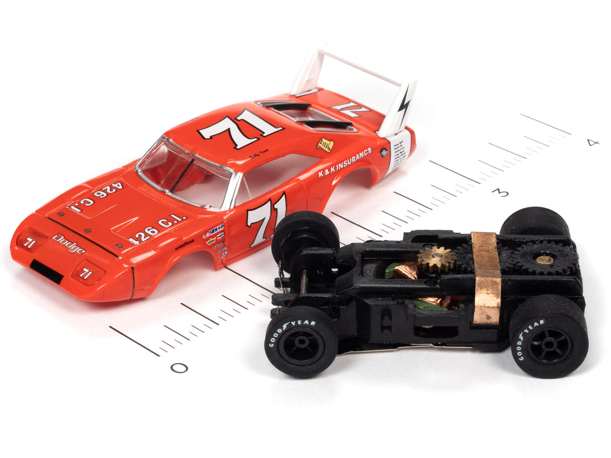 Red and black slot car race cars on a ruler for scale comparison for Auto World SC355