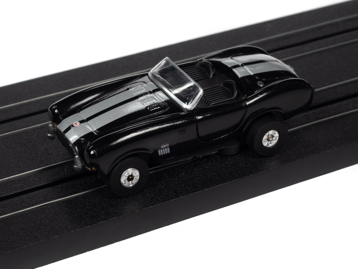 Black and silver slot car on a black track for Auto World SC360