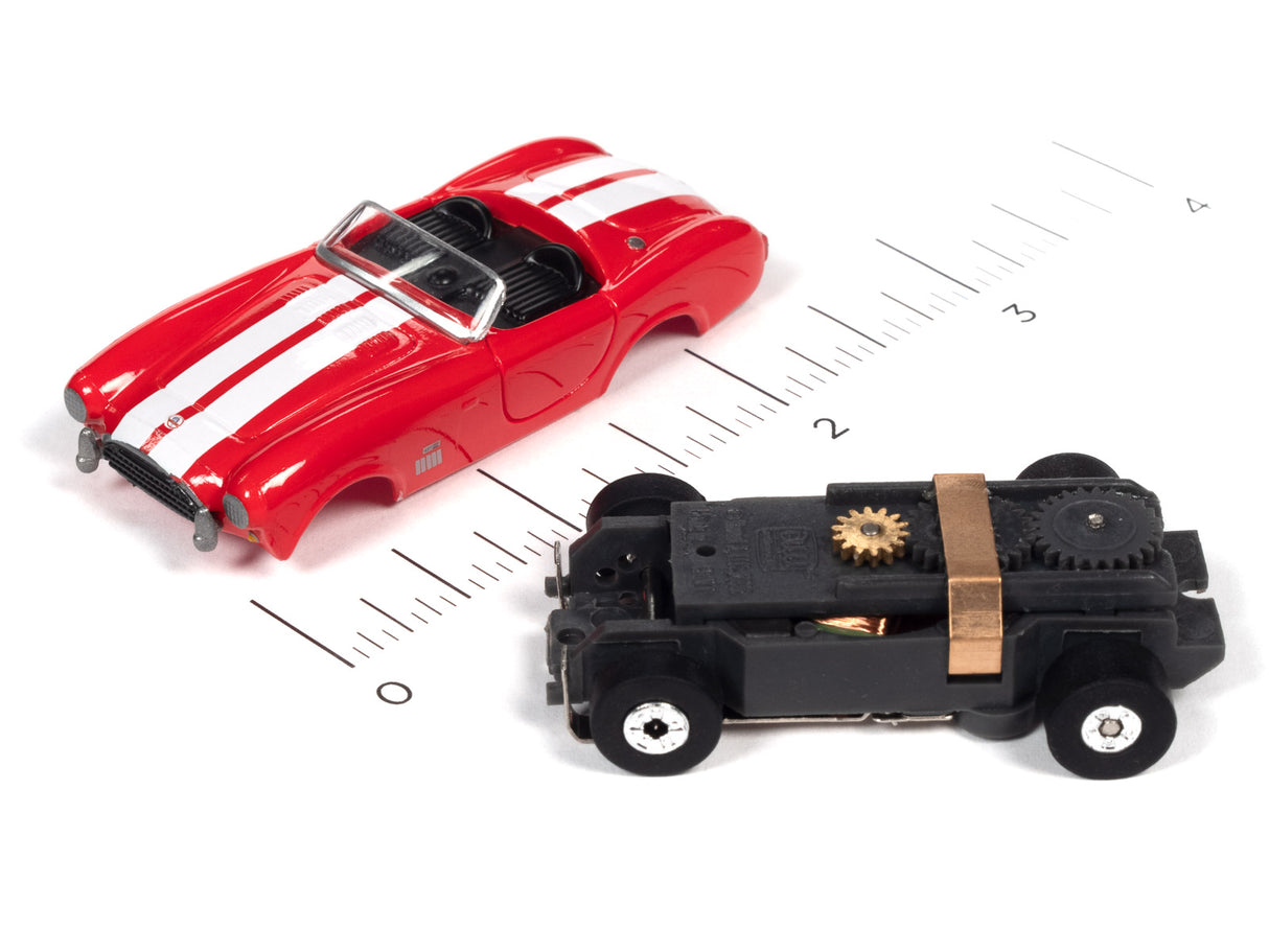 Red and black slot cars on a ruler for scale comparison for Auto World SC360