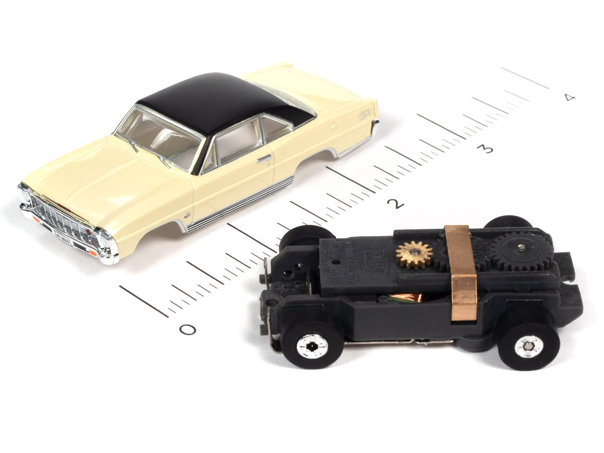 Two slot cars, a yellow coupe and a black, mechanical-looking vehicle, on a ruler for Auto World SC360