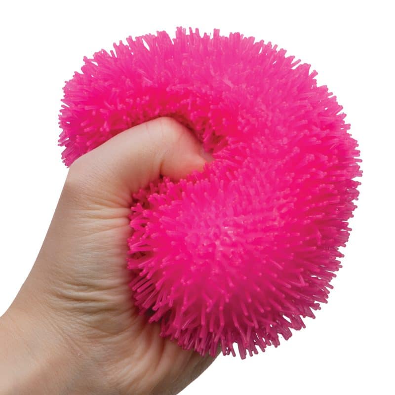 Bright pink, shaggy, round toy held in a hand for Schylling SHND
