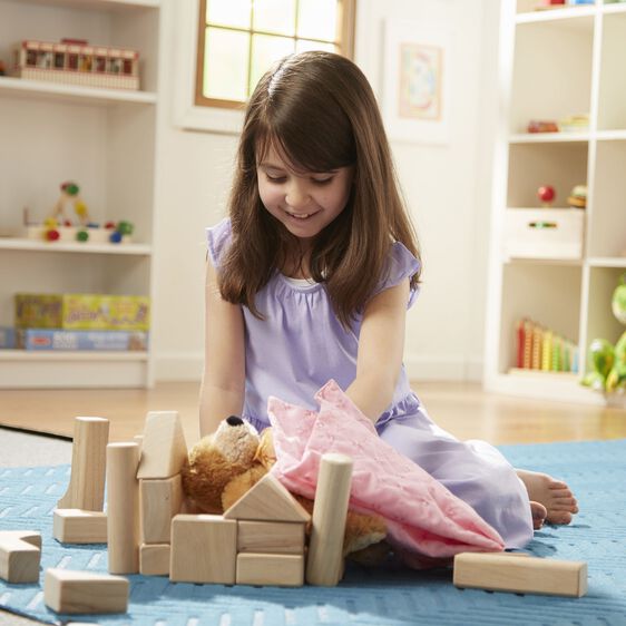 Girl plays with wooden blocks and a stuffed animal on a blue mat for Melissa and Doug 503