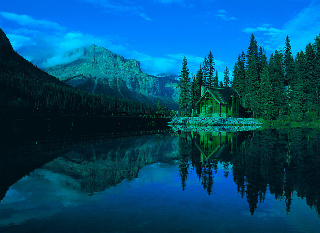 Lodge reflected in calm water with mountains and forest backdrop for Tomax TOM50-045