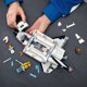 Hands assembling a white LEGO space shuttle model with loose pieces for 31117