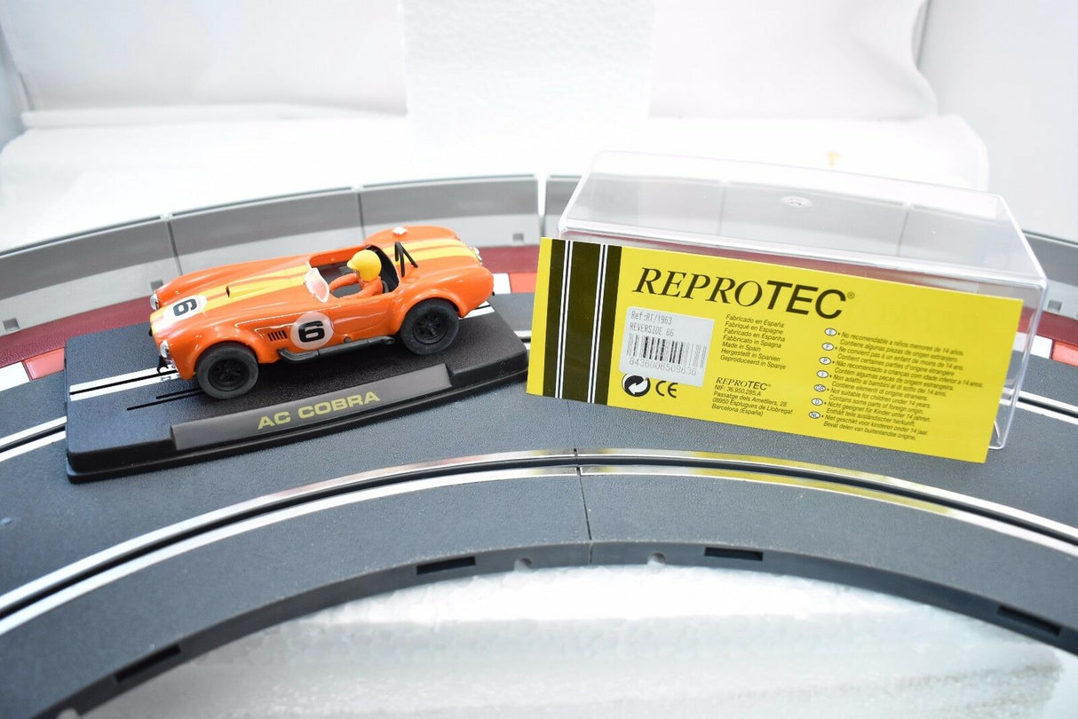 Orange AC Cobra model car on a display stand with product info for ReproTec RT/1963