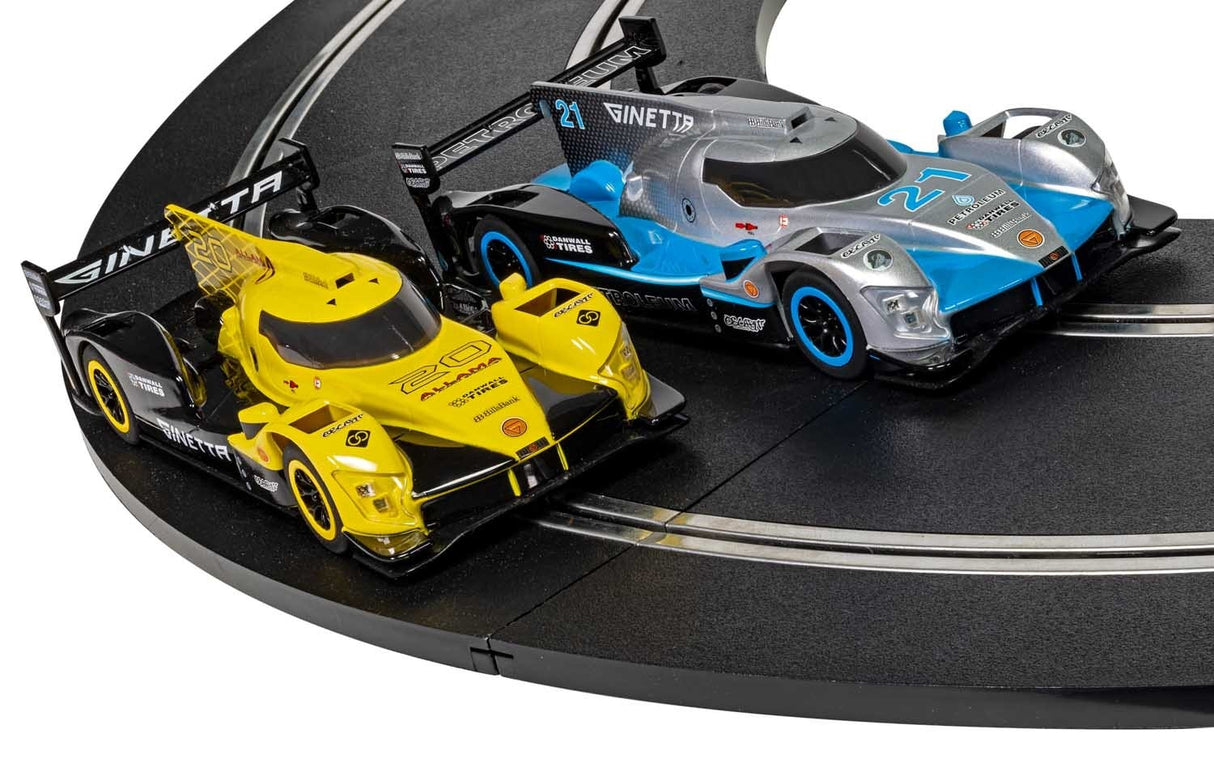 Three slot car race cars on a black track set for Scalextric C1412