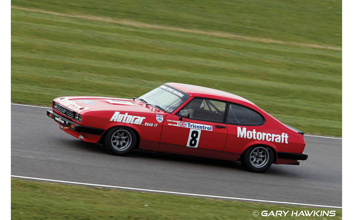 Red Ford Capri race car speeding on a grassy track for Scalextric C4250