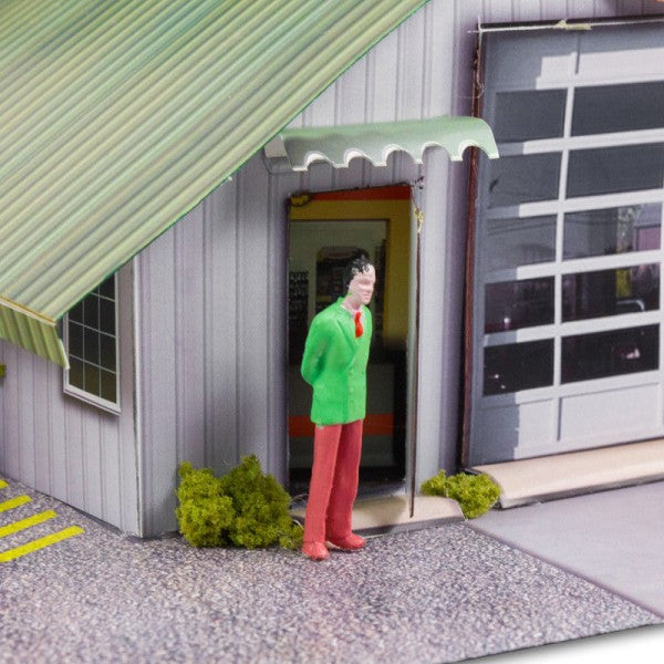 Man stands outside a model garage with a green awning for Innovative Hobby Supply BK4810