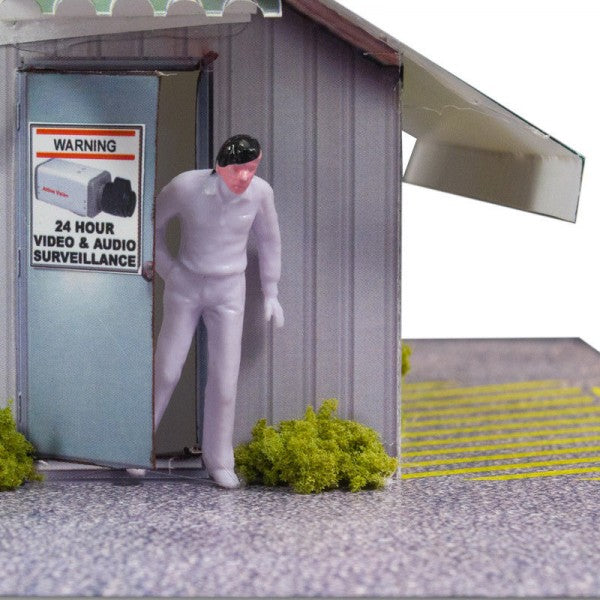 Man stands by a garage with a "24 Hour Video and Audio Surveillance" sign for Innovative Hobby Supply BK4810