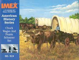 Wagon and prairie schooner set with oxen and people in a grassy field for IMEX 513