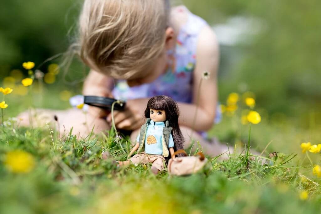 Diorama: Small doll in grass near a child's hands for Lotti LT053