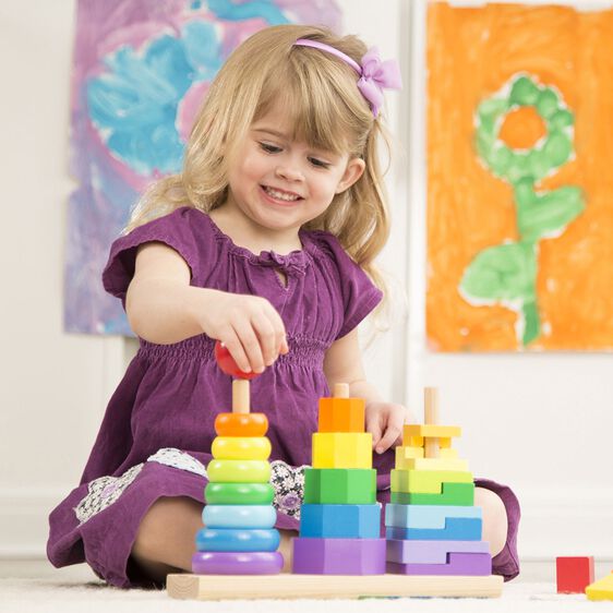 Young girl plays with colorful, stacking wooden toy blocks for Melissa and Doug 567