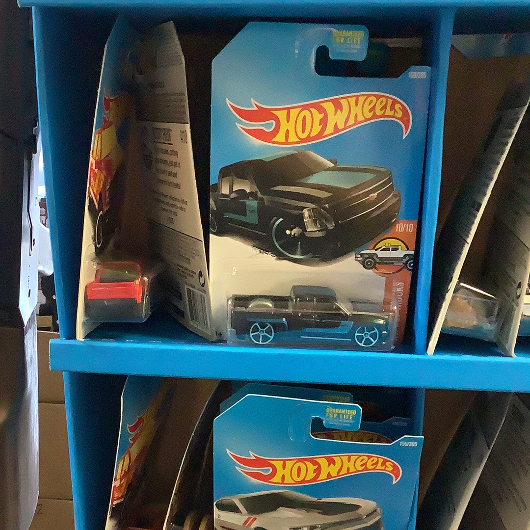 Assorted die-cast toy cars displayed in blue shelving units for UPD FDY58-K910 l Assorted
