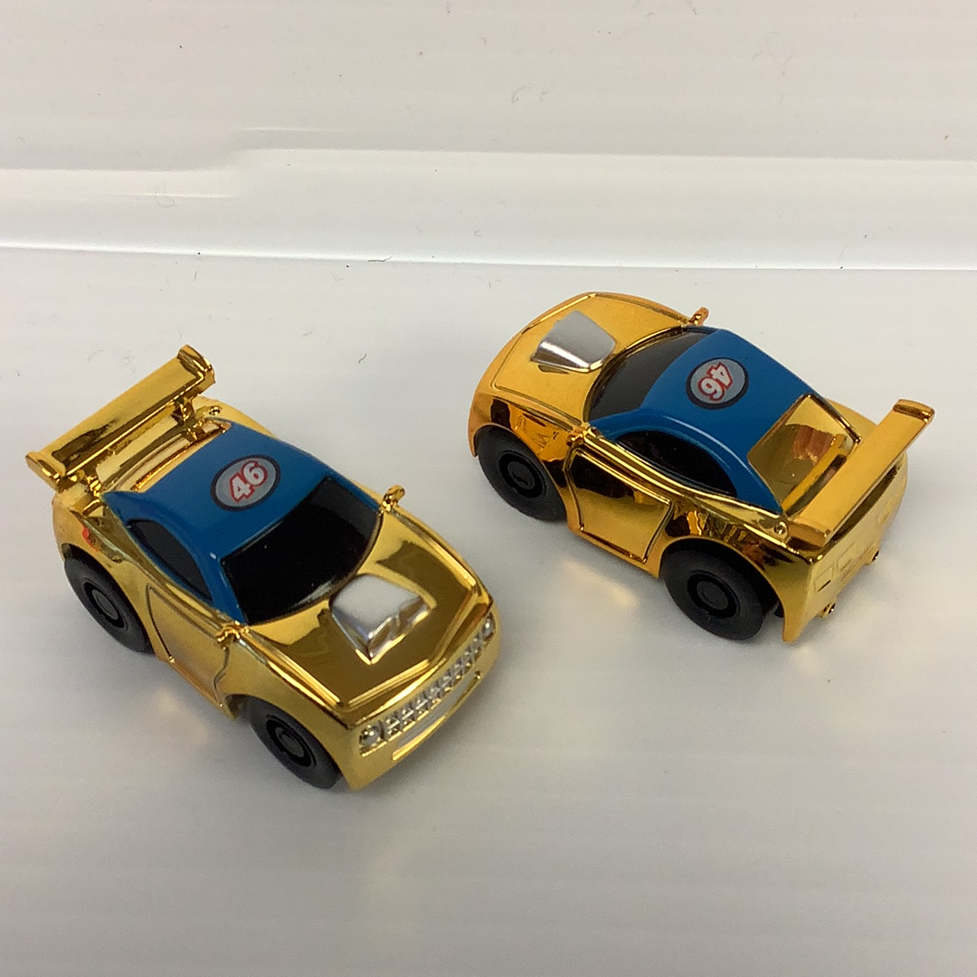 Two gold stock car toys with blue and black accents for California Creations 20602, front view