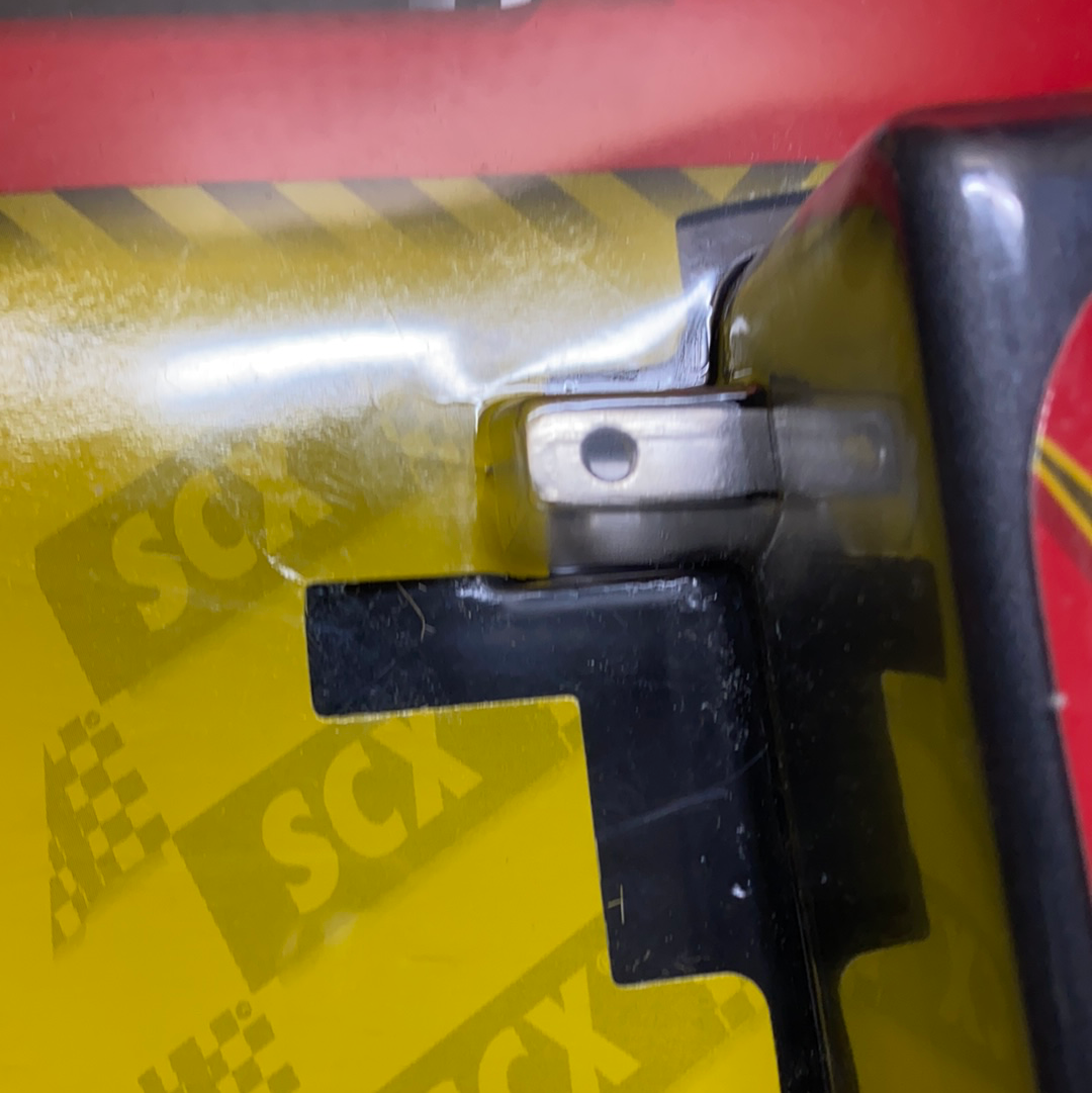 Close-up of a yellow and black plastic mechanism with silver metal joint for SCX 88060