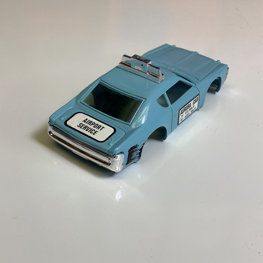 Blue toy taxi cab with "AIRPORT SERVICE" lettering on the side for Aurora / AFX / Tomy B1939B, front view