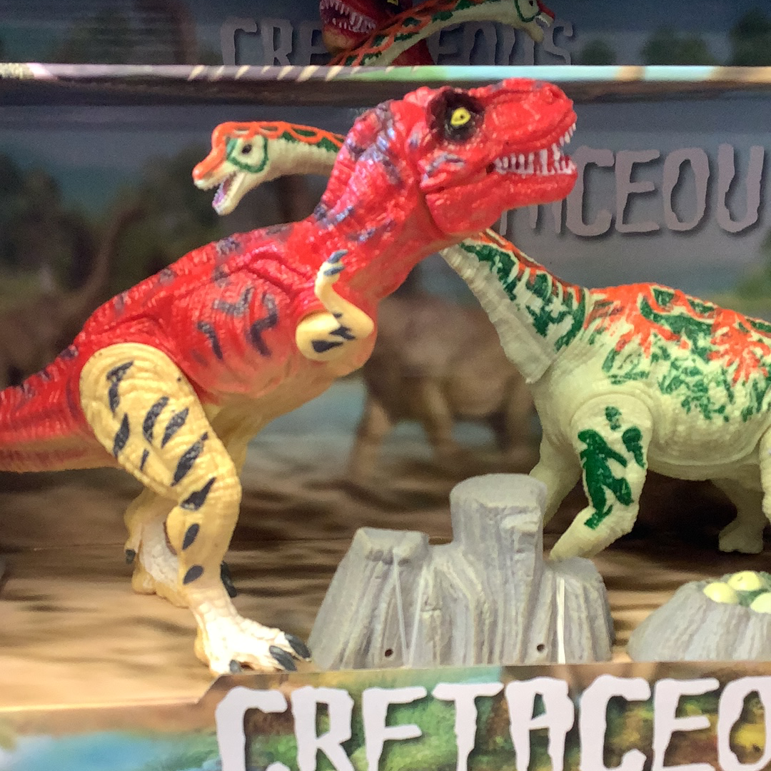 Three articulated dinosaur figures: red, green, and brown, posed on a rocky diorama for 3 dinosaurs 49012