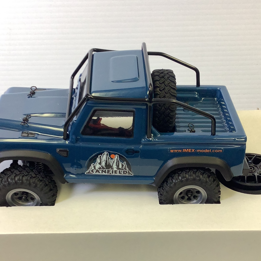Blue scale model crawler with off-road tires and roof rack for IMX IMX25050
