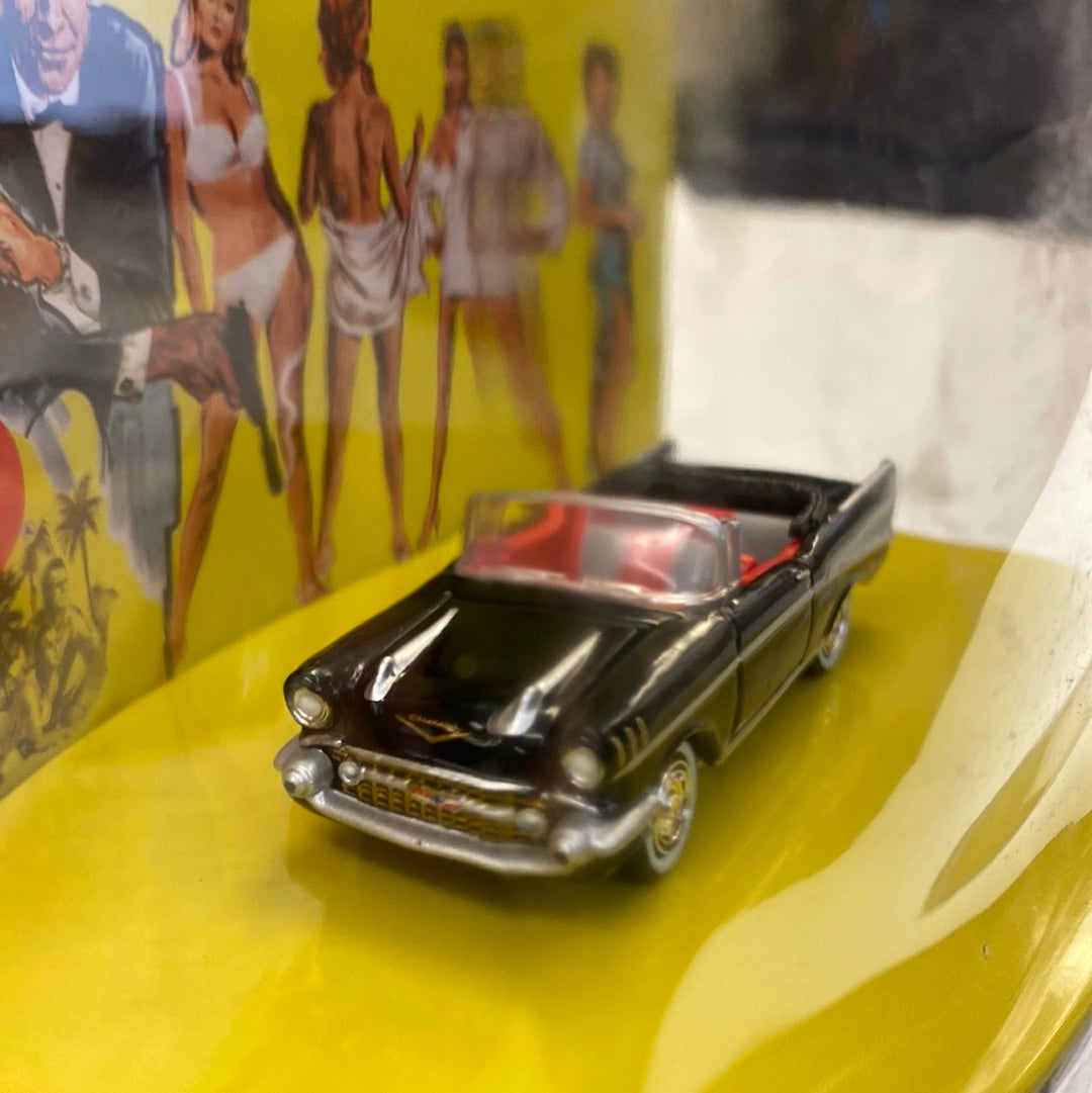 Black 1957 Bel Air convertible die-cast model car on yellow surface for Johnny Lightning JLDR013