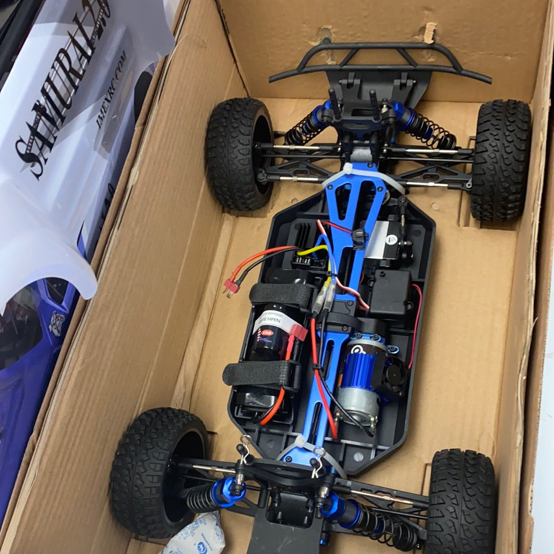 RC car components laid out in a cardboard box for IMEX 22010